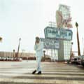 Sammy Davis Jr. is seen in all his King of Cool glory in this classic 1967 photograph by Milton H. Greene. Taken in front of the original Sands Casino sign in Las Vegas, Sammy is wearing a white corduroy suit and red turtleneck sweater and black boots. This image has been used many times on Sammy album covers as well as version on comedian Chris Rock DVD.