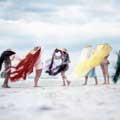 On assignment for Look Magazine in 1956, Milton H Greene snapped this fun, color photograph of six models on Jones Beach, New York each wearing beach hats with flowing grass of different colors covering their faces except the model on the far right. The model on the far right is wearing a blue pant suit and is the only face seen.The rest of the models are wearing 50's era beach-ware, swimsuits, bathing suits.